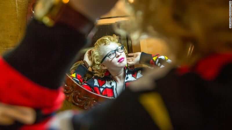 A contestant poses for the camera while getting ready for the pageant. image via CNN